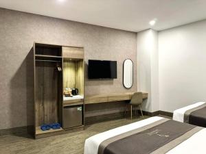 a hotel room with two beds and a television at LION 6 HOTEL in Can Tho