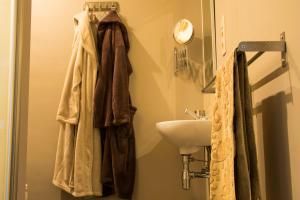 een badkamer met een wastafel en een handdoek bij Vakantiewoning Casa Maran in een groene omgeving te Heusden-Zolder in Heusden - Zolder