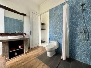 a bathroom with a toilet and a sink and a shower at The Winaposa in Munduk