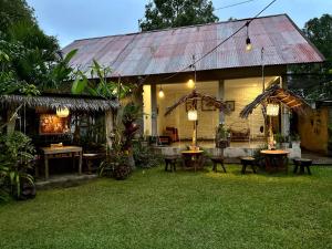 a house with tables and chairs in a yard at The Winaposa in Munduk