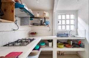 a white kitchen with a stove and a sink at KingsLanding in Morelos