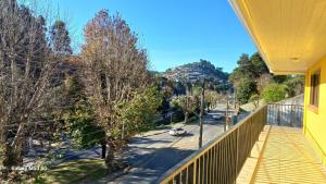 カンポス・ド・ジョルドンにあるApartamento Kit 01, em Campos do Jordãoの通りの景色を望む黄色の家のバルコニー +14枚の写真