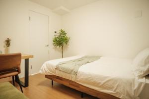 東京にあるSunRise STAY Nakano Sakaueのベッドルーム1室(ベッド1台、デスク、植物付) +18枚の写真