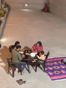 a group of people sitting around a table eating food at Aditya Homestay Dalhousie in Dalhousie