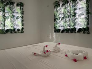two swans sitting on a bed in front of a window at airaMIudi in Watamu