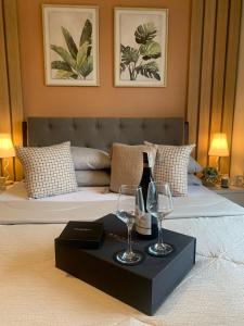 a bed with two wine glasses on a black tray at Alpine Villas Greens Staycation at Crosswinds Tagaytay in Tagaytay