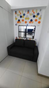a black couch in a room with a mirror at Smdc Wind Marcelle's Place Cool Suites in Tagaytay