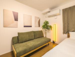 東京にあるSunRise STAY Nakano Sakaueのベッドが2つある部屋にある緑のソファ