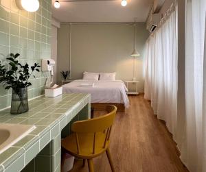 a bedroom with a bed and a desk with a chair at La Moon House in Salaya