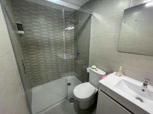 a bathroom with a shower and a toilet and a sink at Mero Habitaciones in Cabo de Palos