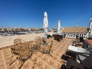 a patio with tables and chairs on a roof at Mero Habitaciones in Cabo de Palos