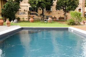 a swimming pool with blue water in a yard at Villa Il Fedino in San Casciano in Val di Pesa