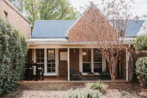 Casa de ladrillo con porche con banco en Kareela Cottage - A Charming Country Getaway, en Mudgee