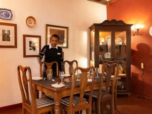 a woman standing behind a table in a dining room at Mount Meru Game Lodge in Arusha