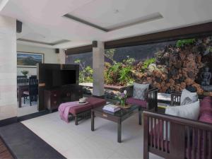 a living room with a large wall with an aquarium at The Ayu Kintamani Villa at Toya Devasya in Kintamani