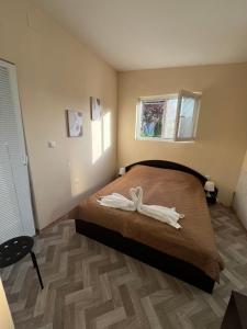 a bedroom with a large bed with a wooden floor at Shabla Lux Guest Houses in Shabla