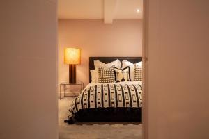 1 dormitorio con 1 cama con almohadas y lámpara en The Greyfriars Apartment, en St Andrews