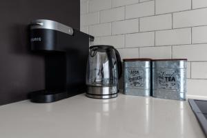 a kitchen counter with a coffee pot and two canisters at Downtown Toronto Condo with Gym & Subway Access in Toronto