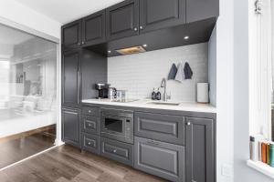 a kitchen with black cabinets and a sink at Downtown Toronto Condo with Gym & Subway Access in Toronto