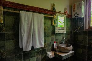 a green tiled bathroom with a sink and a sink at Kresna Asih House in Tampaksiring