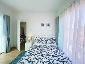 une chambre avec un lit avec un couvre-lit bleu et blanc dans l'établissement Prime Stay Home Nan, à Nan