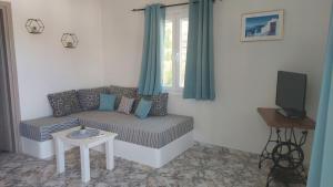 a living room with a couch and a tv at Endless Blue in Pera Gyalos