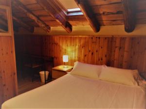 a bedroom with a bed and a lamp on a table at Hotel Roc de St Miquel & Apartment in Soldeu