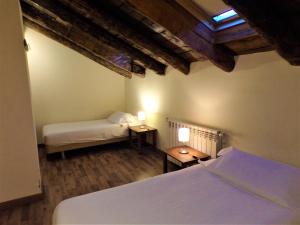 a bedroom with two beds and two tables with lamps at Hotel Roc de St Miquel & Apartment in Soldeu