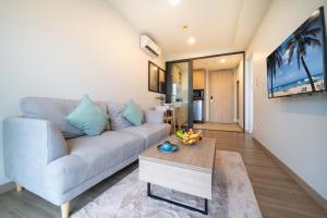 un salon avec un canapé et une table dans l'établissement Greenery Views 1 BR Laguna SkyLine Apartment B2512 just 10 min walk Bangtao Beach, à Laguna Phuket
