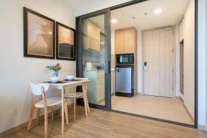 une cuisine et une salle à manger avec une table et des chaises dans l'établissement Greenery Views 1 BR Laguna SkyLine Apartment B2512 just 10 min walk Bangtao Beach, à Laguna Phuket