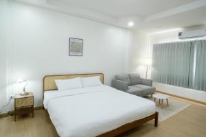 Ban Na ThoDaisy Home&cafe Nan的一间带床和椅子的白色卧室