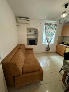 a living room with a brown couch in a room at Apartmani Luciano in Novalja