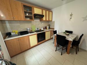 a small kitchen with a table and a table and chairs at Apartmani Luciano in Novalja