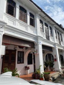 Qiyis Cottage في جورج تاون: مبنى ابيض امامه نباتات