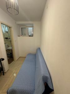 a bedroom with a blue bed against a wall at Apartmani Luciano in Novalja