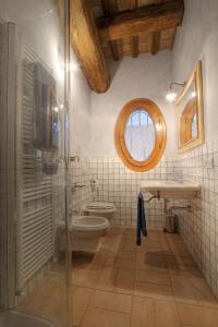 a bathroom with a toilet and a sink and a window at La Fornasaccia in Cesena