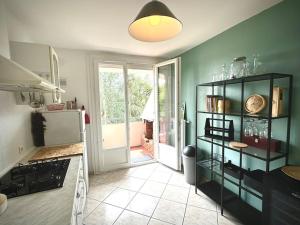 a kitchen with a green wall and a refrigerator at Superbe, 3 chambres, au calme, parkings in Décines-Charpieu