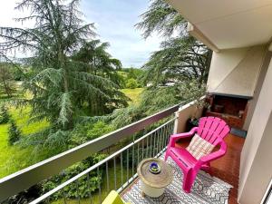 a pink chair sitting on the balcony of a house at Superbe, 3 chambres, au calme, parkings in Décines-Charpieu +18 photos