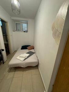 a small room with a bed in the corner at Apartmani Luciano in Novalja