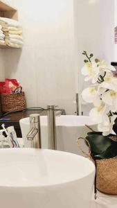 a bathroom with a tub and a vase of white flowers at Sunrise from bed Apartment - NhaTrang Beach in Nha Trang +111 photos