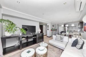a living room with a white couch and a table at The Icon Capetown in Cape Town