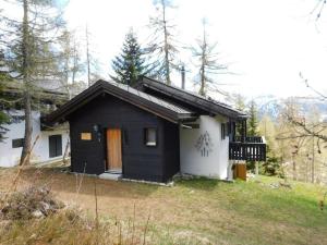 a small black and white house in the woods at Chalet Silentium in Bellwald