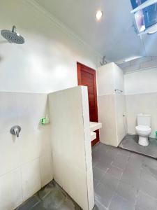 a bathroom with a toilet and a red door at Pererenan nengah guest house in Canggu