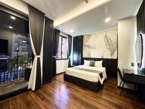 a bedroom with a bed and a desk in it at LION 10 HOTEL in Can Tho