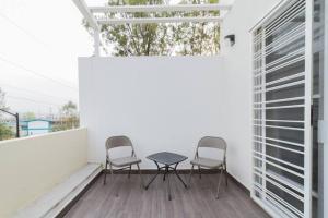 a patio with two chairs and a table on a balcony at Casa para grupos grandes por el ITESO in Guadalajara