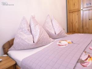 un lit avec des oreillers roses dessus dans l'établissement Kiki's, à Fažana 30 autres photos