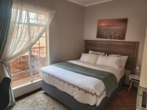 un dormitorio con una cama y una ventana en Sable woods, en Pretoria