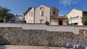a house with a stone wall next to a swimming pool at Villa Les Terrasses Tamaris Les Sablettes in La Seyne-sur-Mer