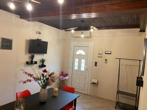 a living room with a table and chairs and a tv at Summer Home in Potos