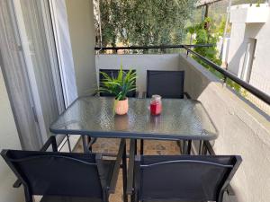a table on a balcony with two chairs and a plant at Summer Home in Potos +22 photos